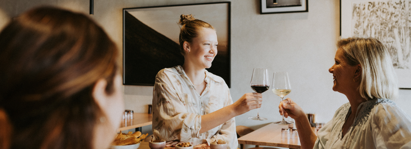 Three women enjoying food and Wayfinder wines